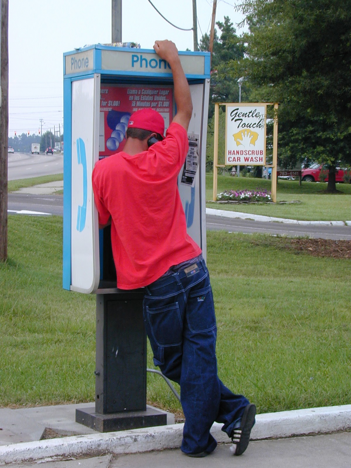 Person using a payphone on Capital Blvd, Raleigh NC, 2003
